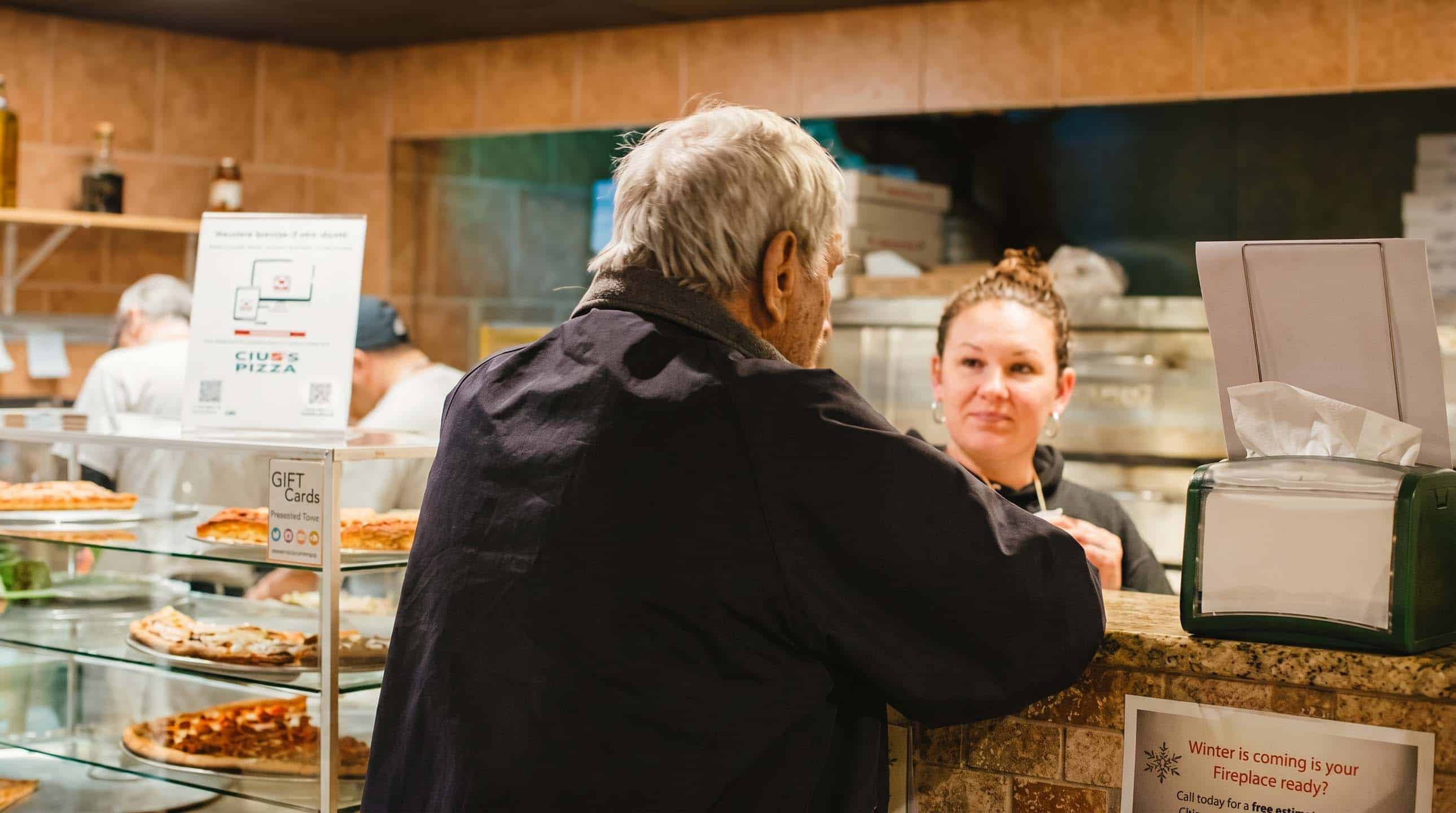 A customer being served at the Ciro's Pizza counter